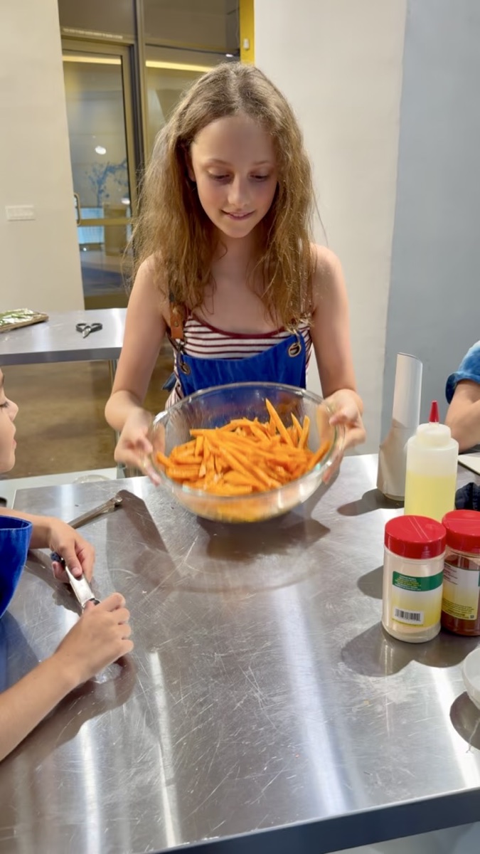 A young cook proud of the vegetables she prepped